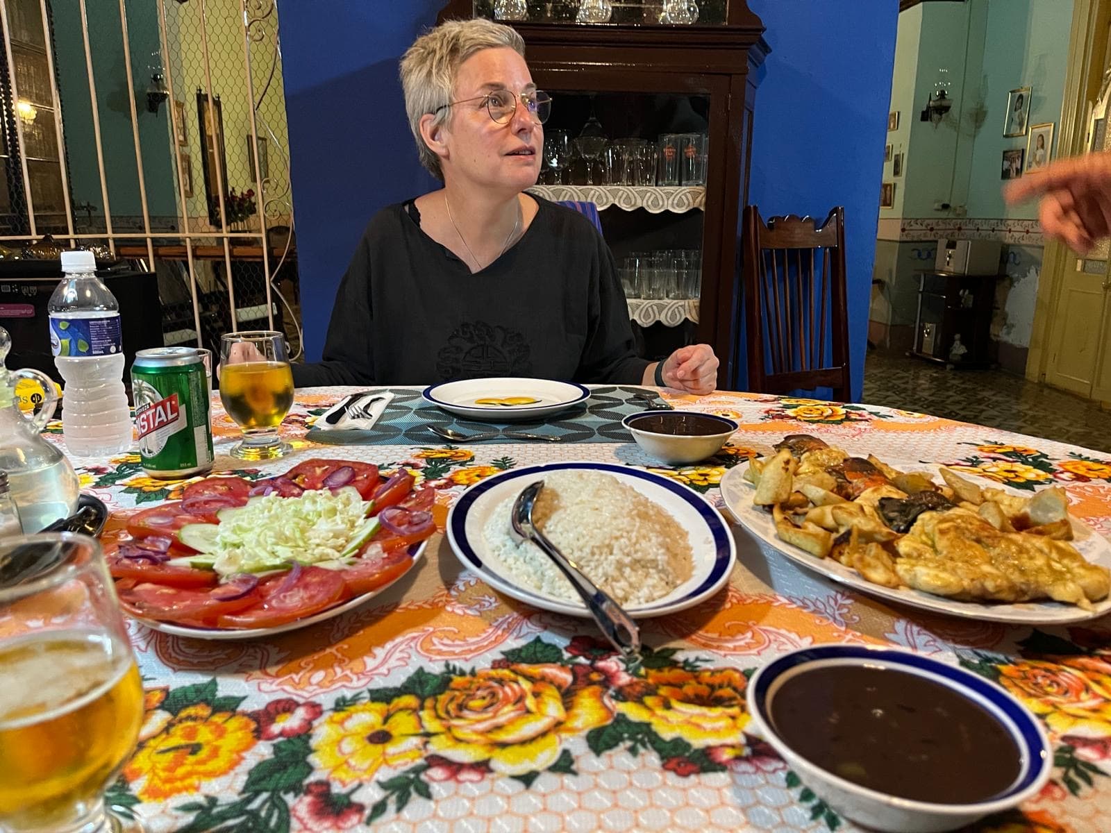 Katharina Hannesschläger an einer gedeckten Tafel mit Reis, Tomatensalat und weiteren Speisen