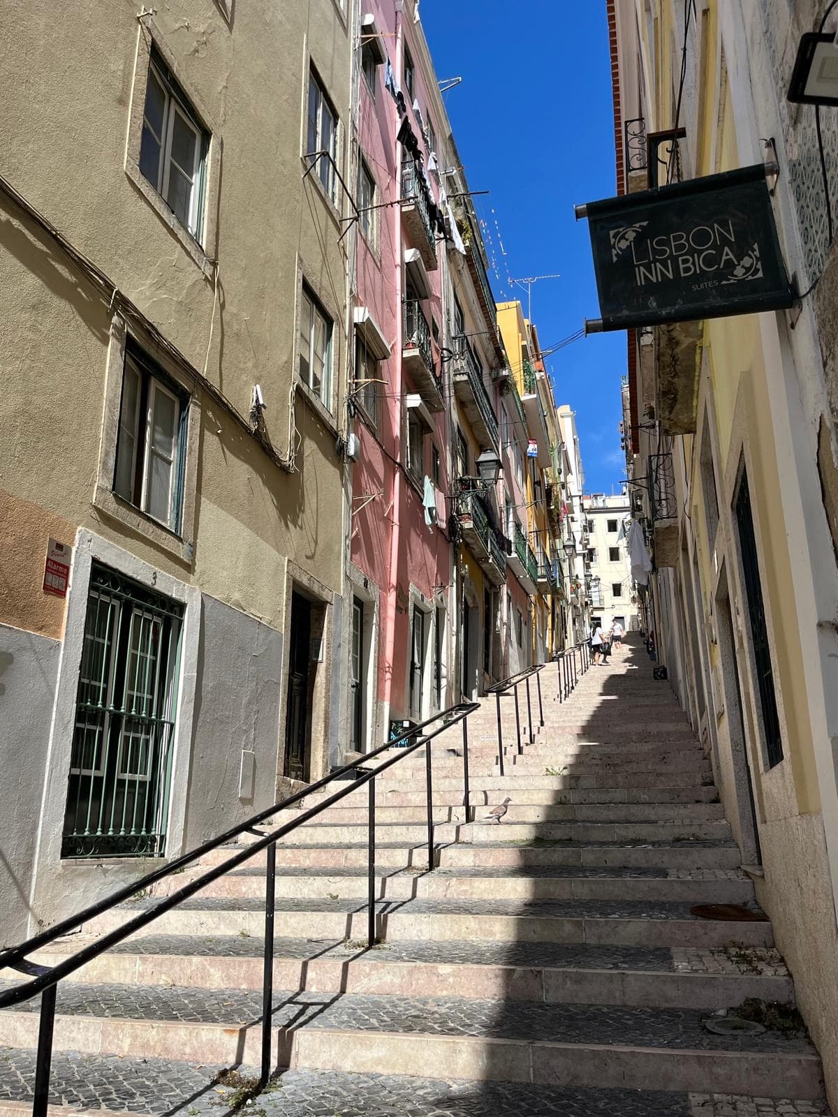 Steile Treppengasse mit bunten Häuserfassaden und Wäscheleinen zwischen den Balkonen